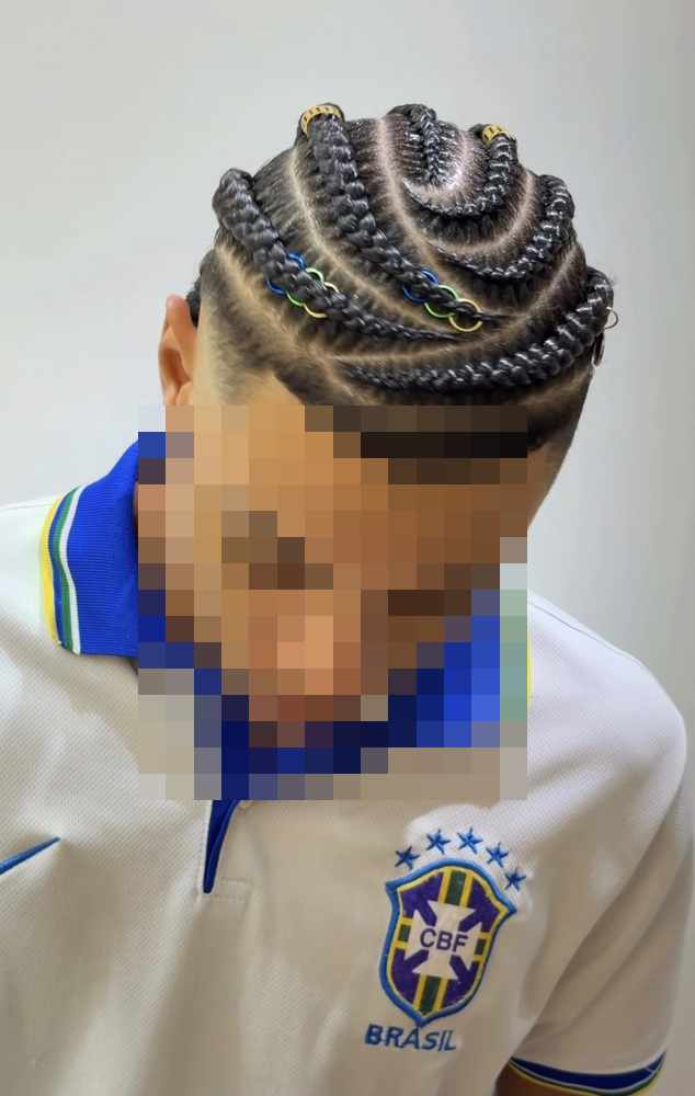 Cornrows curving around the head in arcs, with coloured rings threaded onto the braids