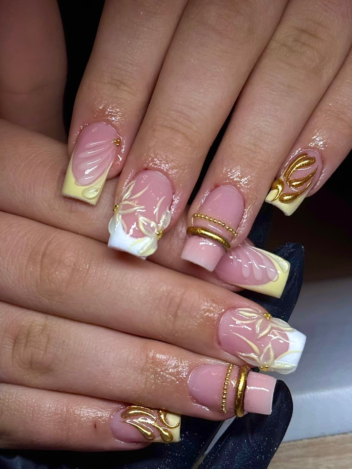 Nail art met gouden ornamenten, parels en 3D-details